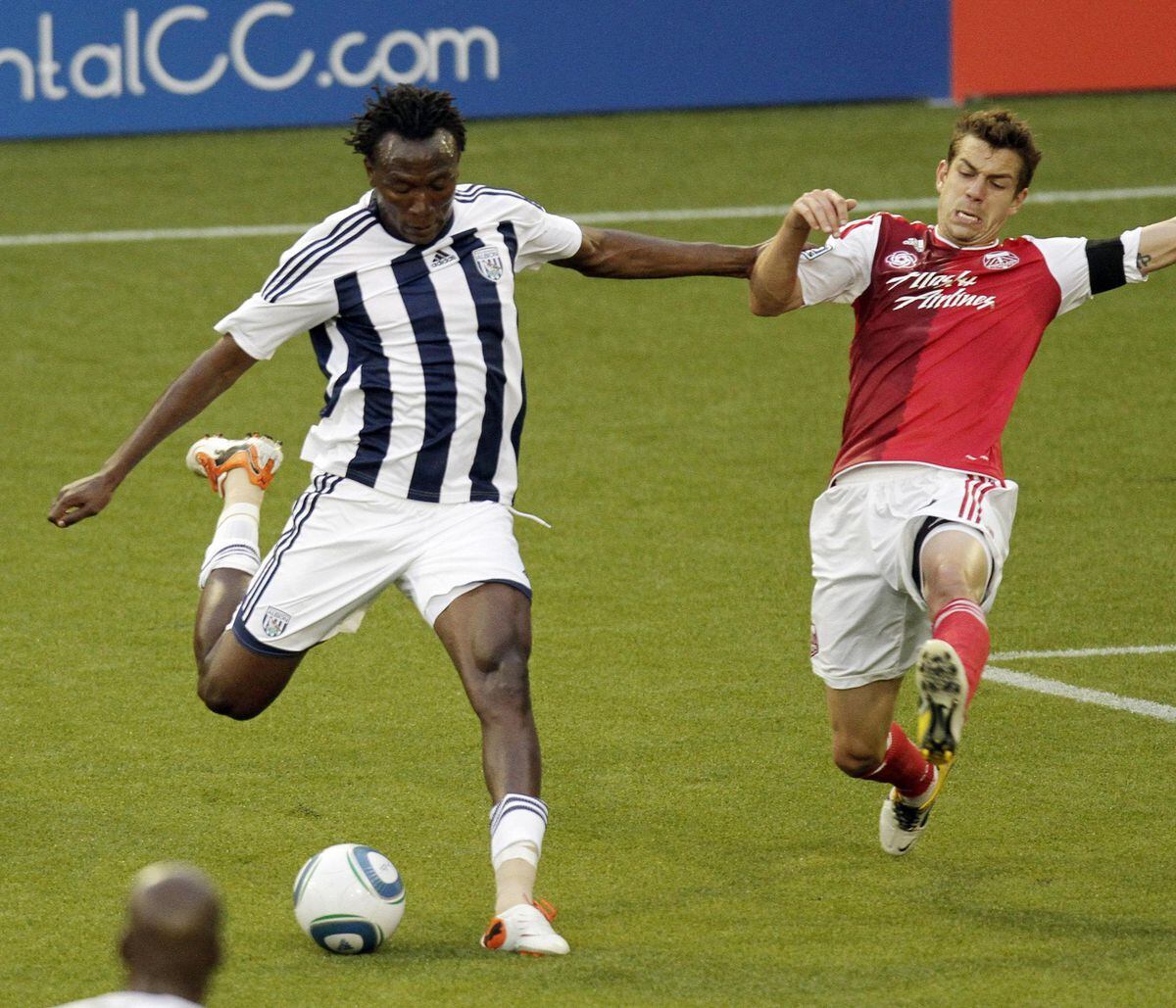 West Bromwich Albion midfielder Somen Tchoyi, left, takes a shot as Portland Timbers defender Eric Brunner defends during the first half of an exhibition soccer game in Portland, Ore., Wednesday, July 20, 2011.(AP Photo/Don Ryan)
