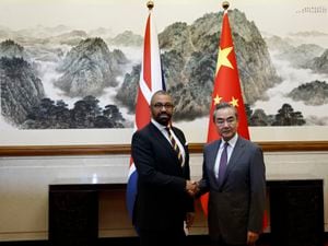 British Foreign Secretary James Cleverly, left, and Chinese Foreign Minister Wang Yi shake hands before a meeting at the Diaoyutai State Guesthouse in Beijing