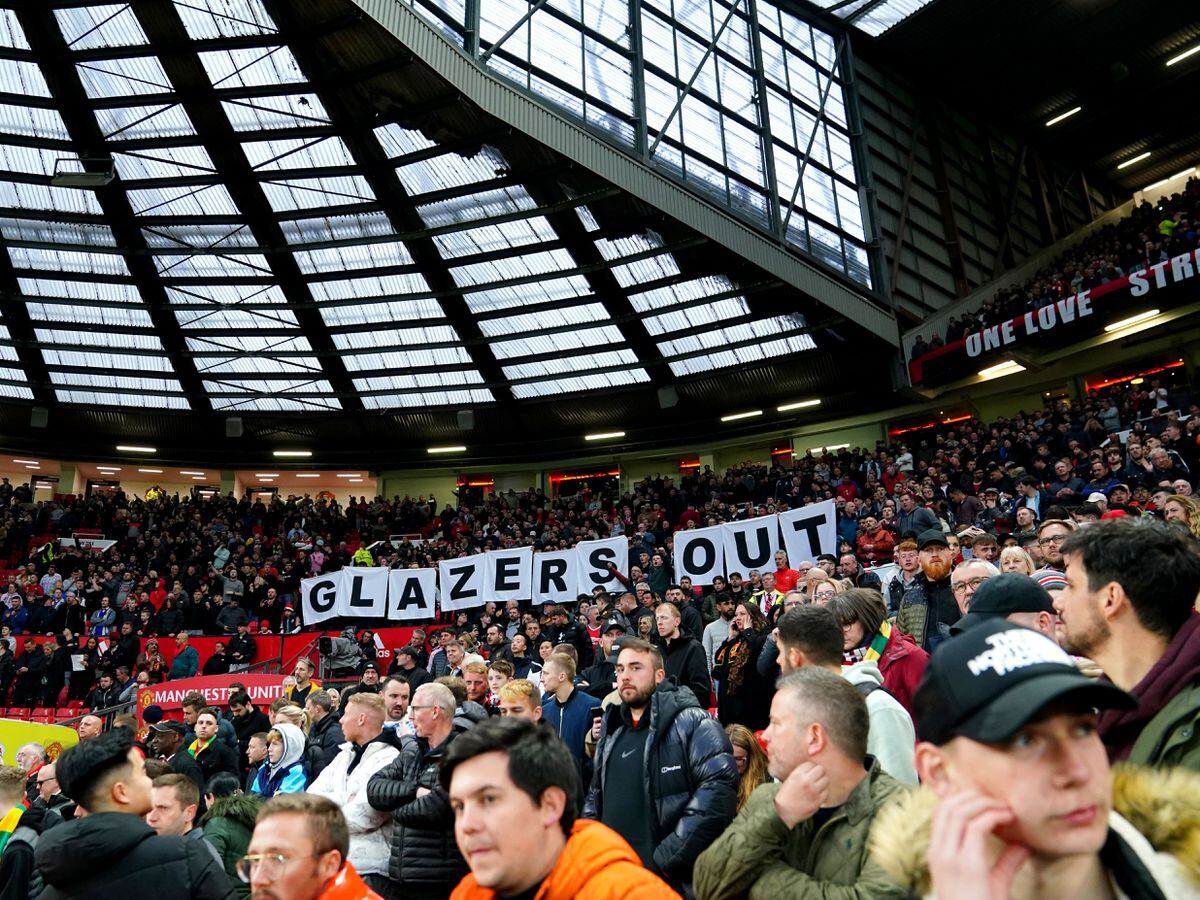 Manchester United fans hold up a 'Glazers out' sign