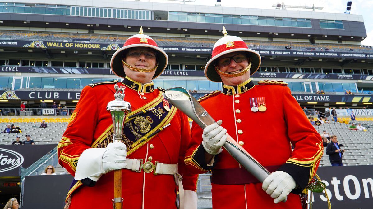 Mounties holding the baton at the football game in Canada