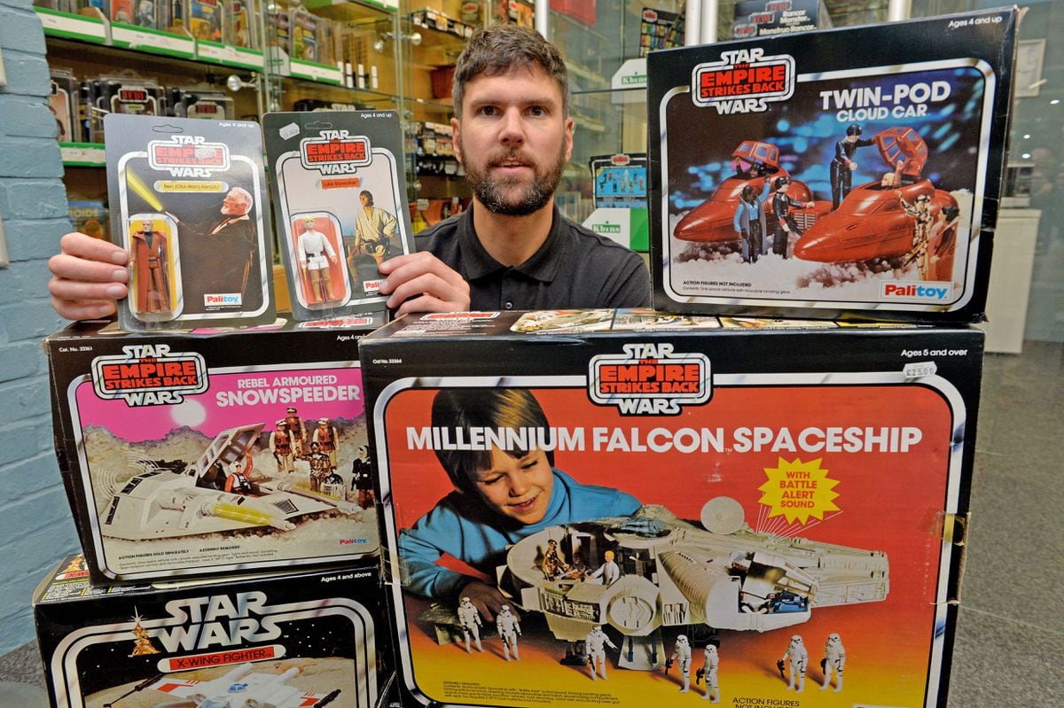 Auctioneer Chris Aston with Star Wars toys up for auction