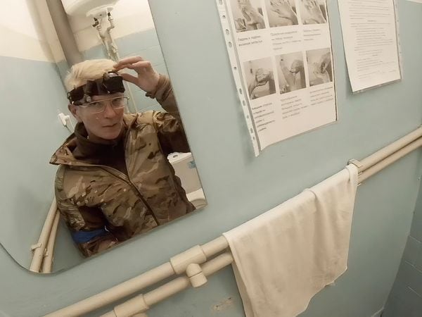 Yuliia Paievska, known as Taira, looks in the mirror and turns off her camera in Mariupol, Ukraine