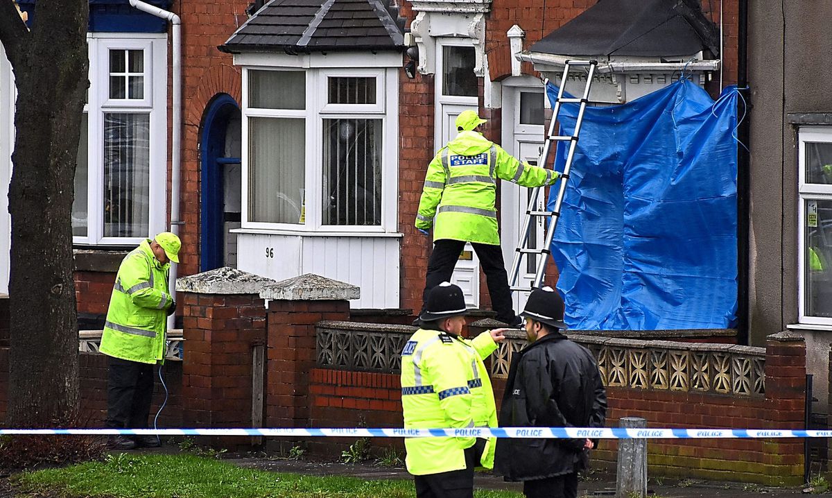 Police staff cover broken windows of a property on Pensnett Road, Brierley Hill