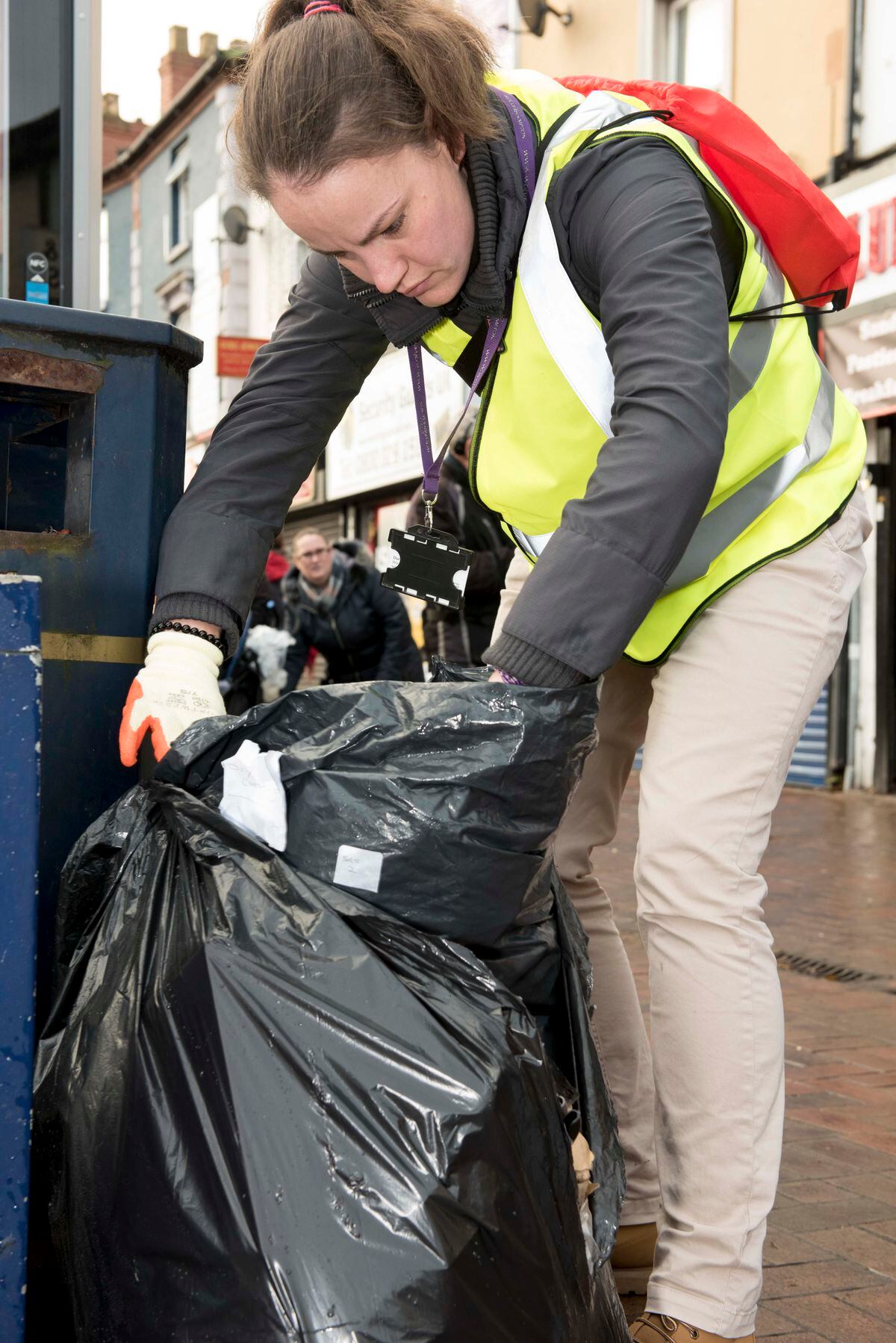 A council officer gets stuck into rubbish dumped outside shops in Blakenhall. 