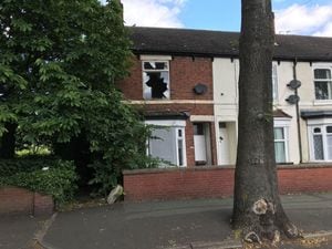 The three-bedroom house is partly boarded up and has a smashed window