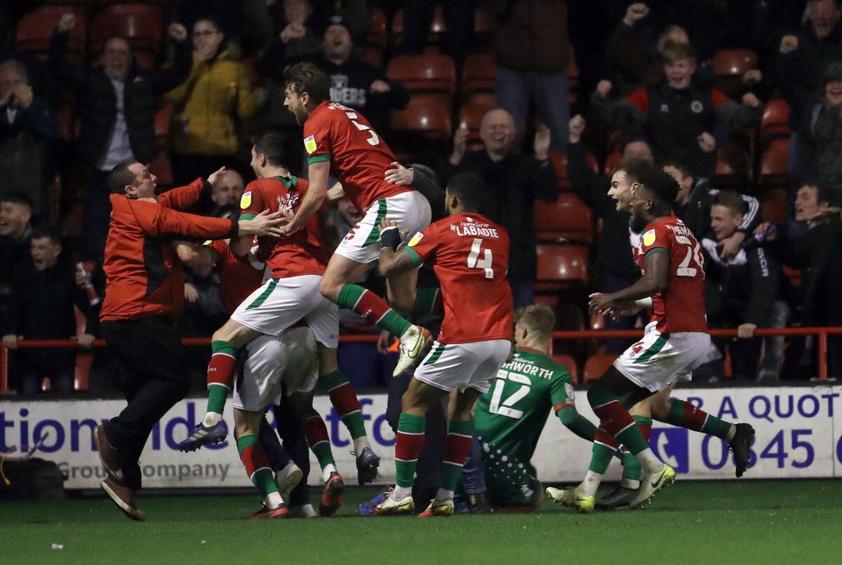 A fan invades the pitch as Walsall's Conor Wilkinson (centre left) celebrates scoring their side's third goal of the game during the Sky Bet League Two match at Banks's Stadium, Walsall. Picture date: Saturday January 1, 2022. PA Photo. See PA story SOCCER Walsall. Photo credit should read: Bradley Collyer/PA Wire...RESTRICTIONS: EDITORIAL USE ONLY No use with unauthorised audio, video, data, fixture lists, club/league logos or "live" services. Online in-match use limited to 120 images, no video emulation. No use in betting, games or single club/league/player publications..