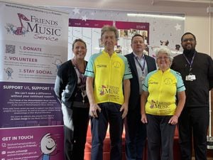 Ted and Denise Pearson are congratulated by Ciaran O'Donnell, Head of Wolverhampton Music Service (centre) and colleagues after completing their epic fundraising bike ride from John O’Groats to Land’s End.
