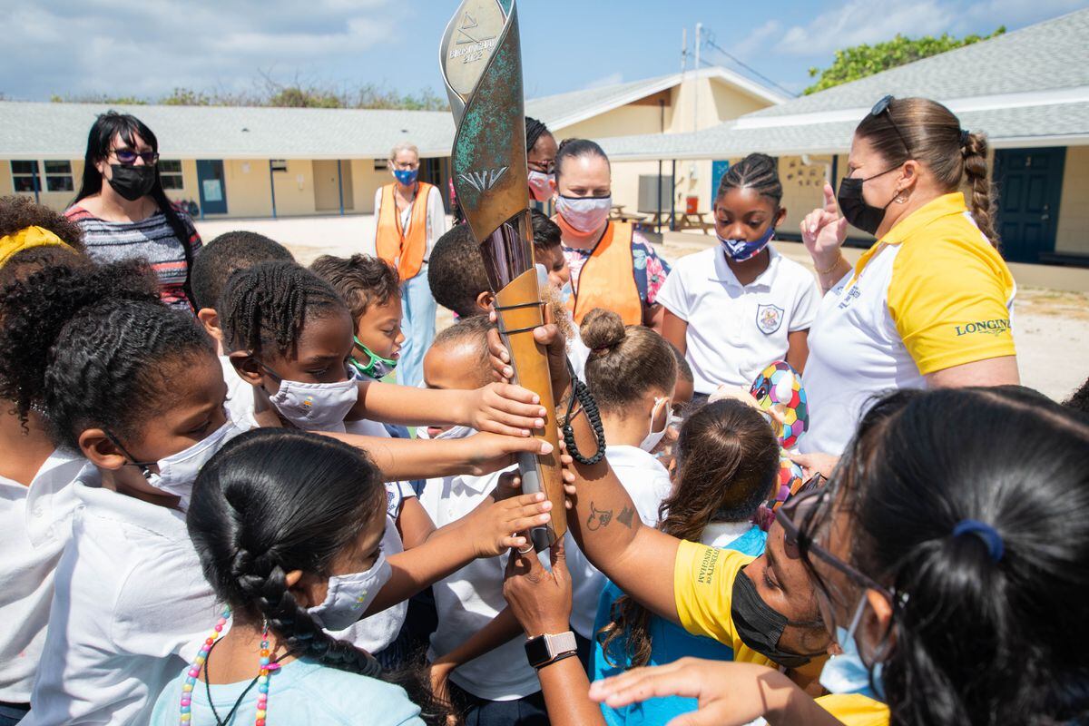 Schoolchildren hold the baton as it crosses the Cayman Islands