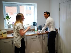 Prime Minister Rishi Sunak speaks with homeowner Jennifer Norton, as he makes a cup of tea in a number 10 mug, in her home during a visit to Crofton Park, near Rednal, Birmingham