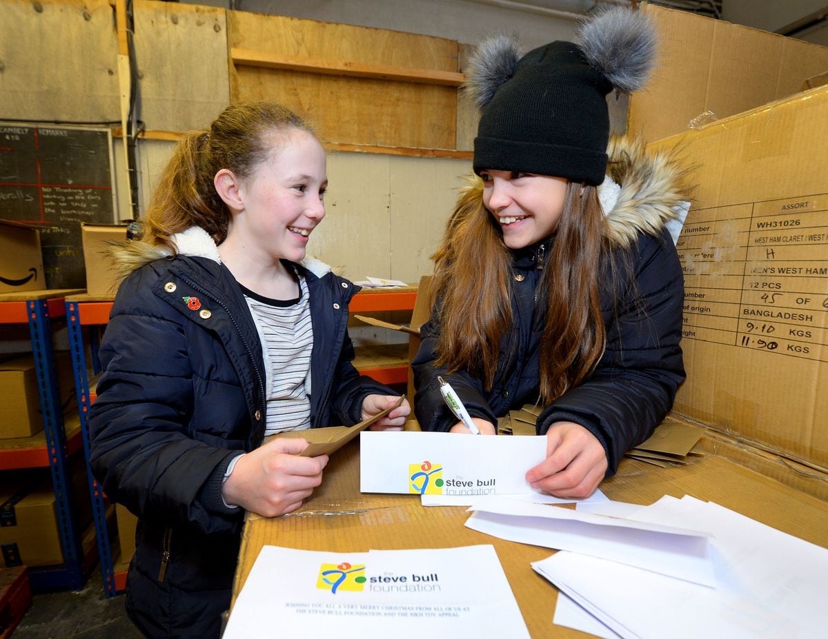 Josie Gough, aged 10, and Gracie Bull, aged 11, write notes to put in the boxes of gifts
