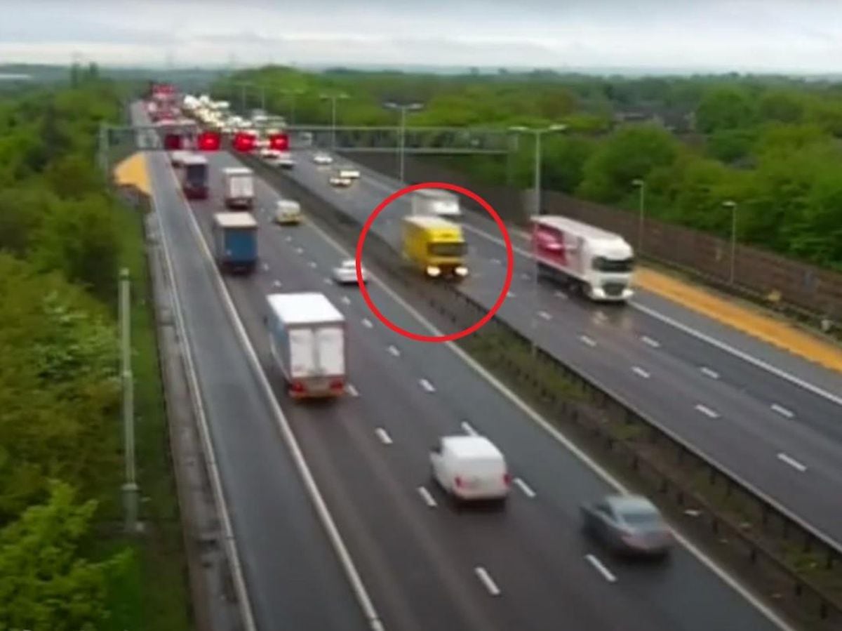 The footage captures the moment the yellow HGV, travelling northbound on the carriageway to the right, veers into the third lane as it comes under the gantry before mounting the central reservation barrier and driving along the steel guard until going out of view