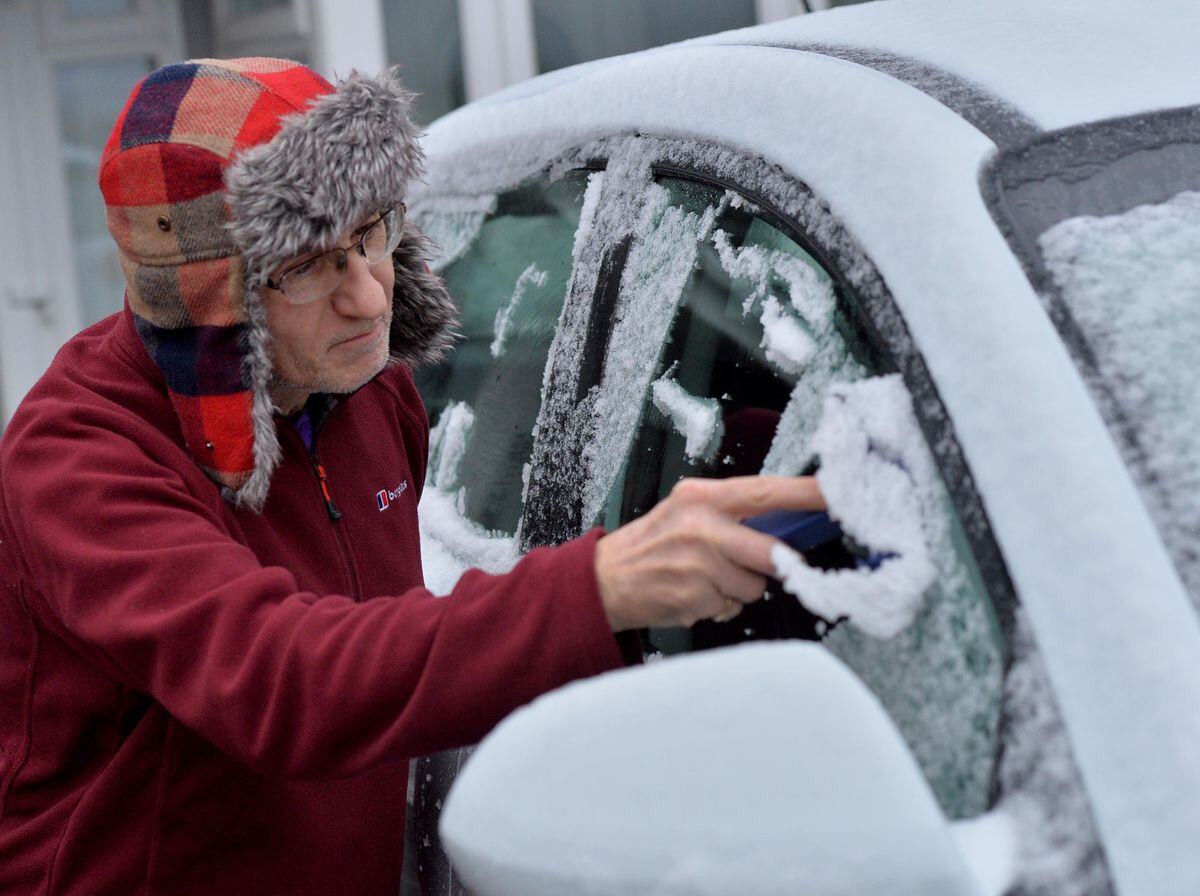 Mike Greaves clears snow from his car in Heath Hayes, Cannock