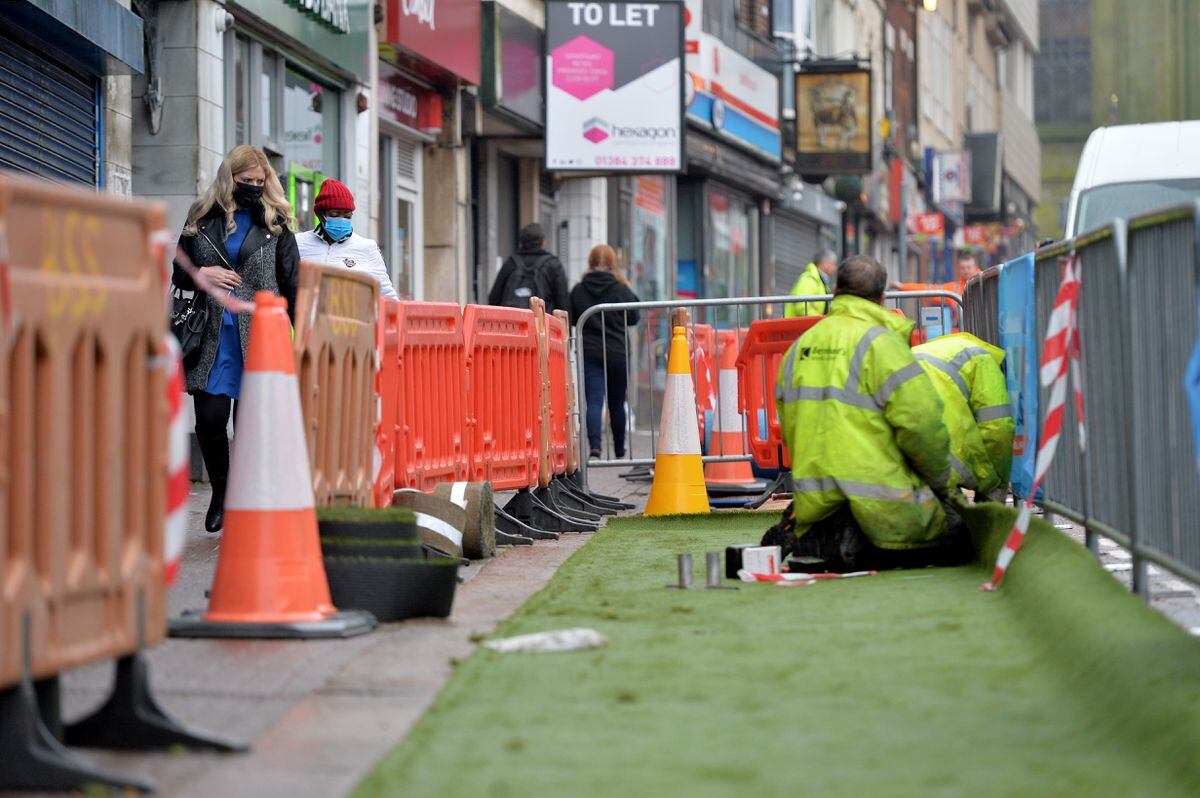 Artificial grass is placed in parking lots on Dudley High Street to aid social distancing
