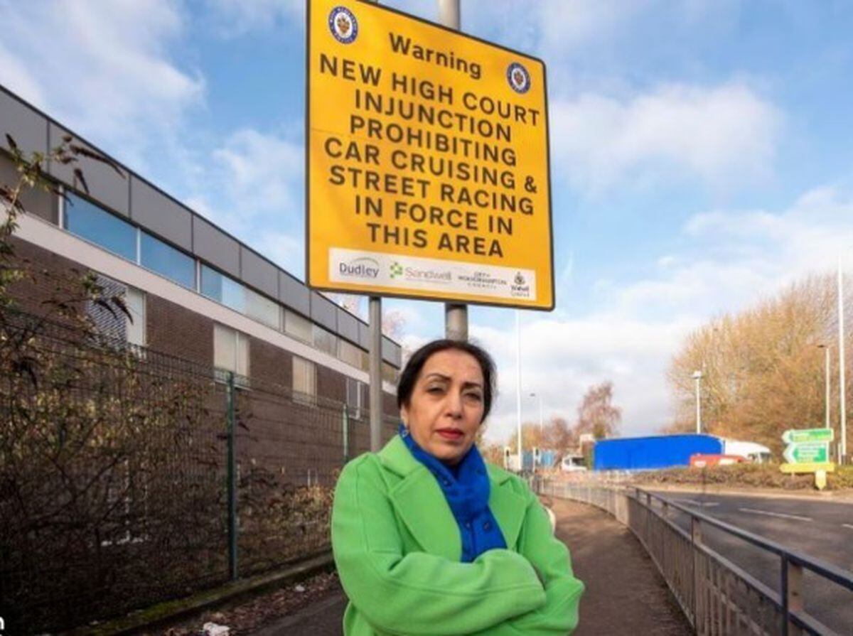 Councillor Jasbir Jaspal with the High Court Injunction Street signage in Bilston.