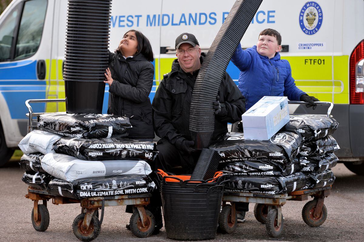 Mike Hall, manager of West Midlands Police's cannabis disposal team, with year six students Iman and Kyle, both aged 10.