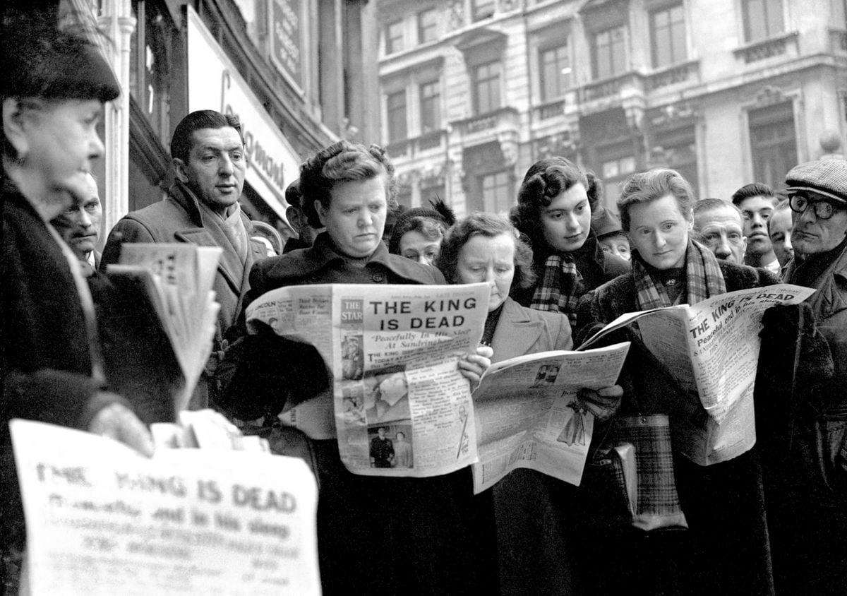 Serious faces on lunch time crowds reflect the tragic news of the death of King George VI, in Ludgate Circus, London