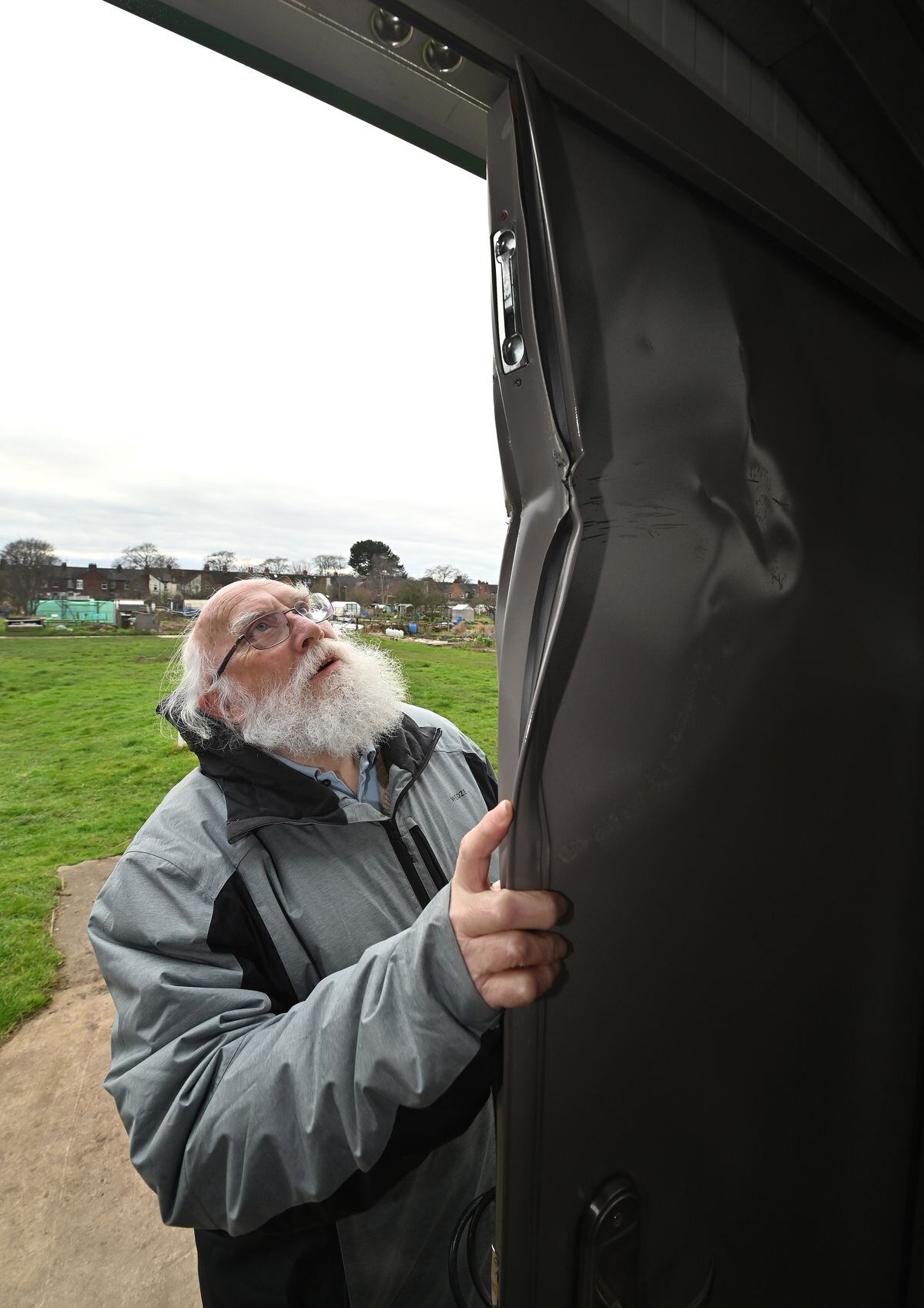 John Edwards inspects a damaged door