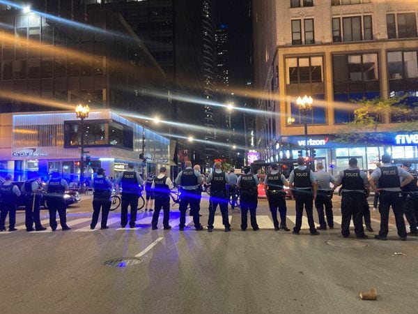 Chicago police block traffic near State and Monroe streets after crowds of young people flooded the Loop after a fatal shooting in Millennial Park in Chicago