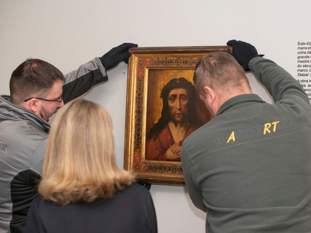 Two people take down the diptych of Ecce Homo