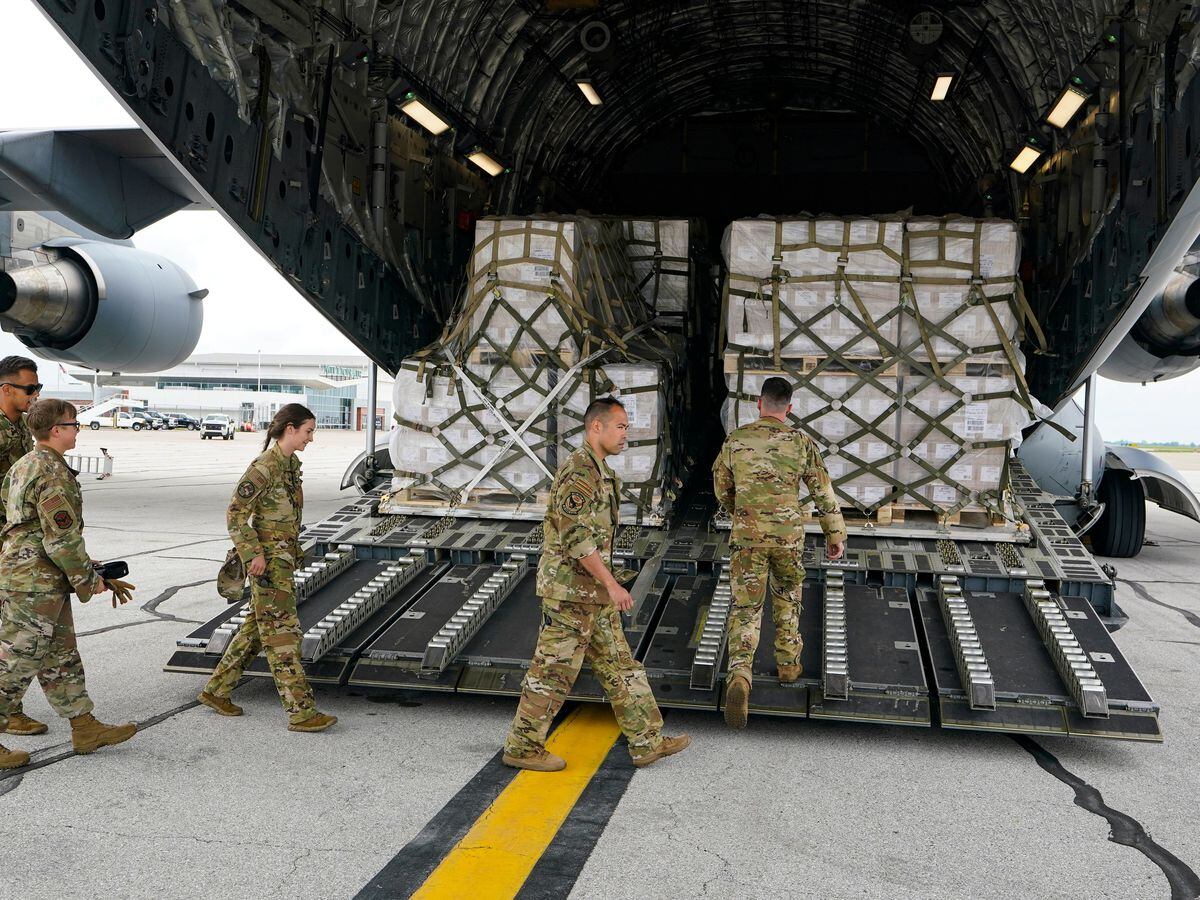 Crew members of a C-17 aircraft unload the baby formula cargo at the Indianapolis International Airport