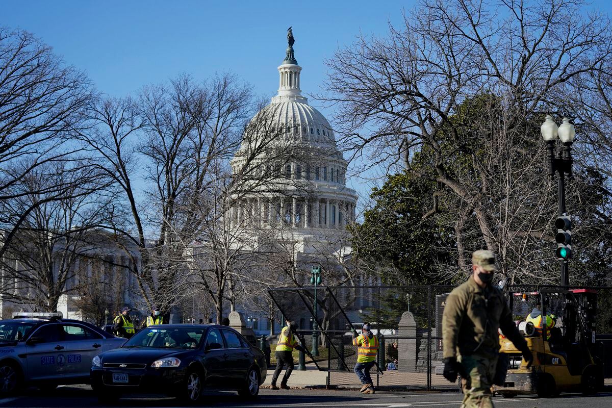 With the U.S. Capitol in the background, workers place fencing around the Capitol grounds the day after violent protesters loyal to President Donald Trump stormed the U.S. Congress in Washington, Thursday, Jan. 7, 2021. (AP Photo/Evan Vucci).