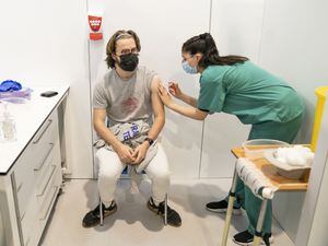 Simran Saughall administers a booster vaccine to Adam Hamilton at a Covid vaccination centre at Elland Road in Leeds
