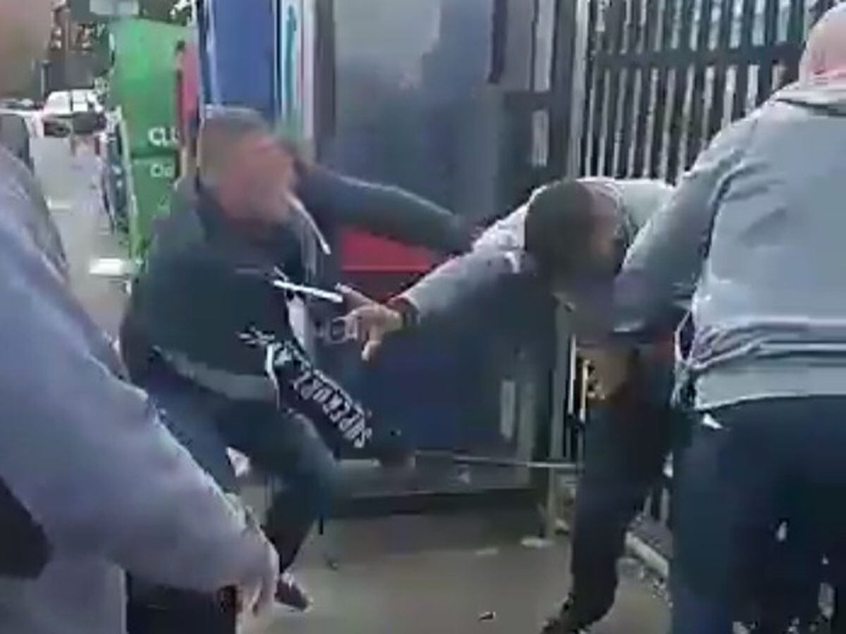 A plain-clothed officer, left, hits a man with his baton in Birmingham
