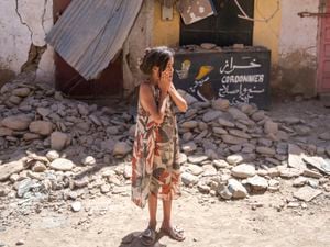 A child reacts after inspecting the damage caused by the earthquake, in her town of Amizmiz, near Marrakech, Morocco
