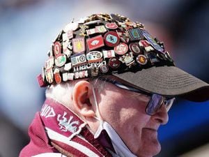 An Aston Villa fan wearing a cap fully adorned with club badges during the Premier League match at the King Power Stadium, Leicester. Picture date: Saturday April 23, 2022.
