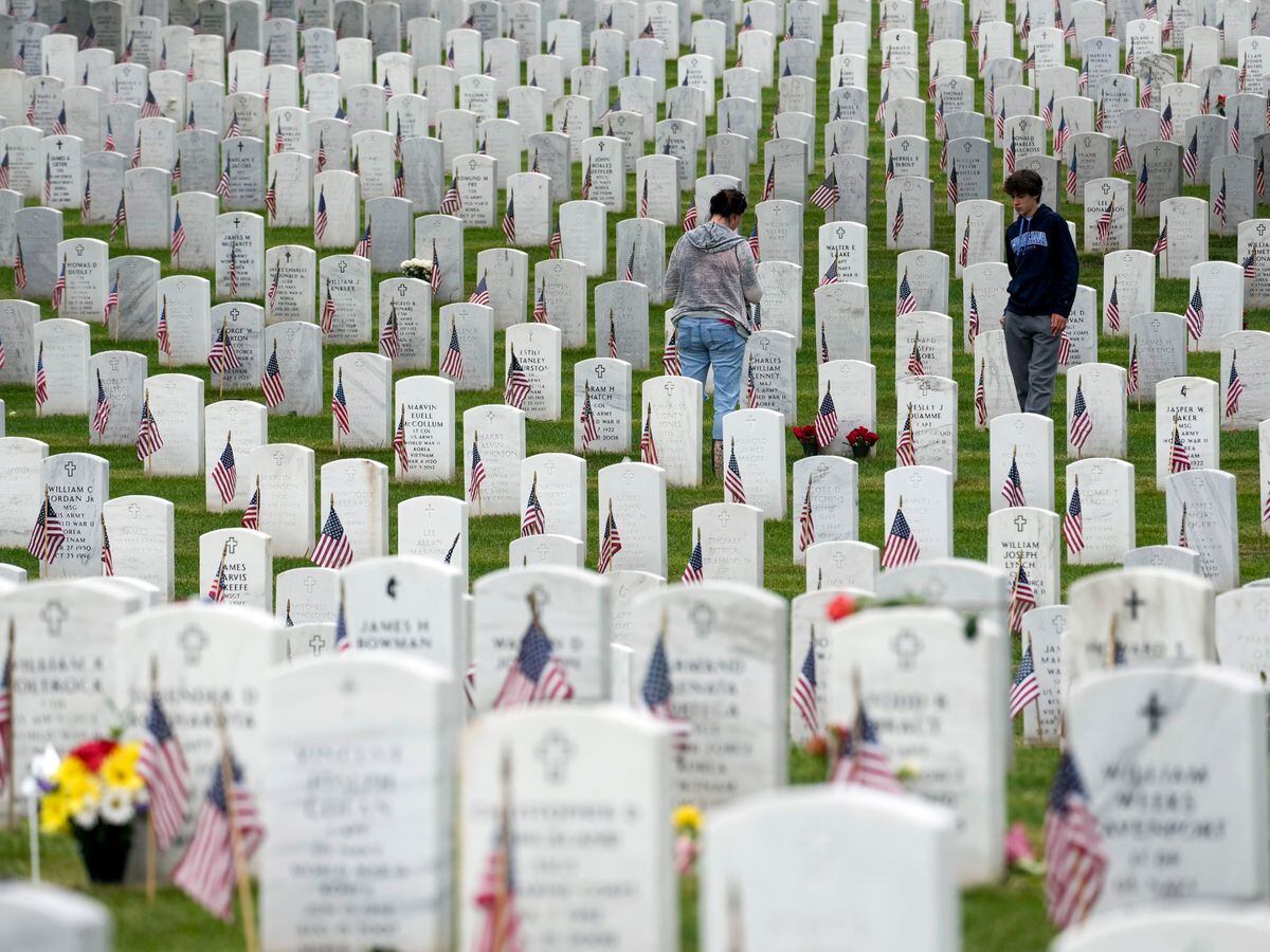 People walk among headstones as they visit Section 60 at Arlington National Cemetery on Memorial Day