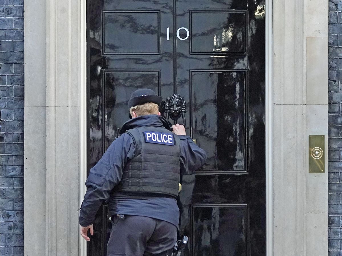 A police officer knocks on the door of the Prime Minister’s official residence in Downing Street, Westminster, London (Stefan Rousseau/PA)
