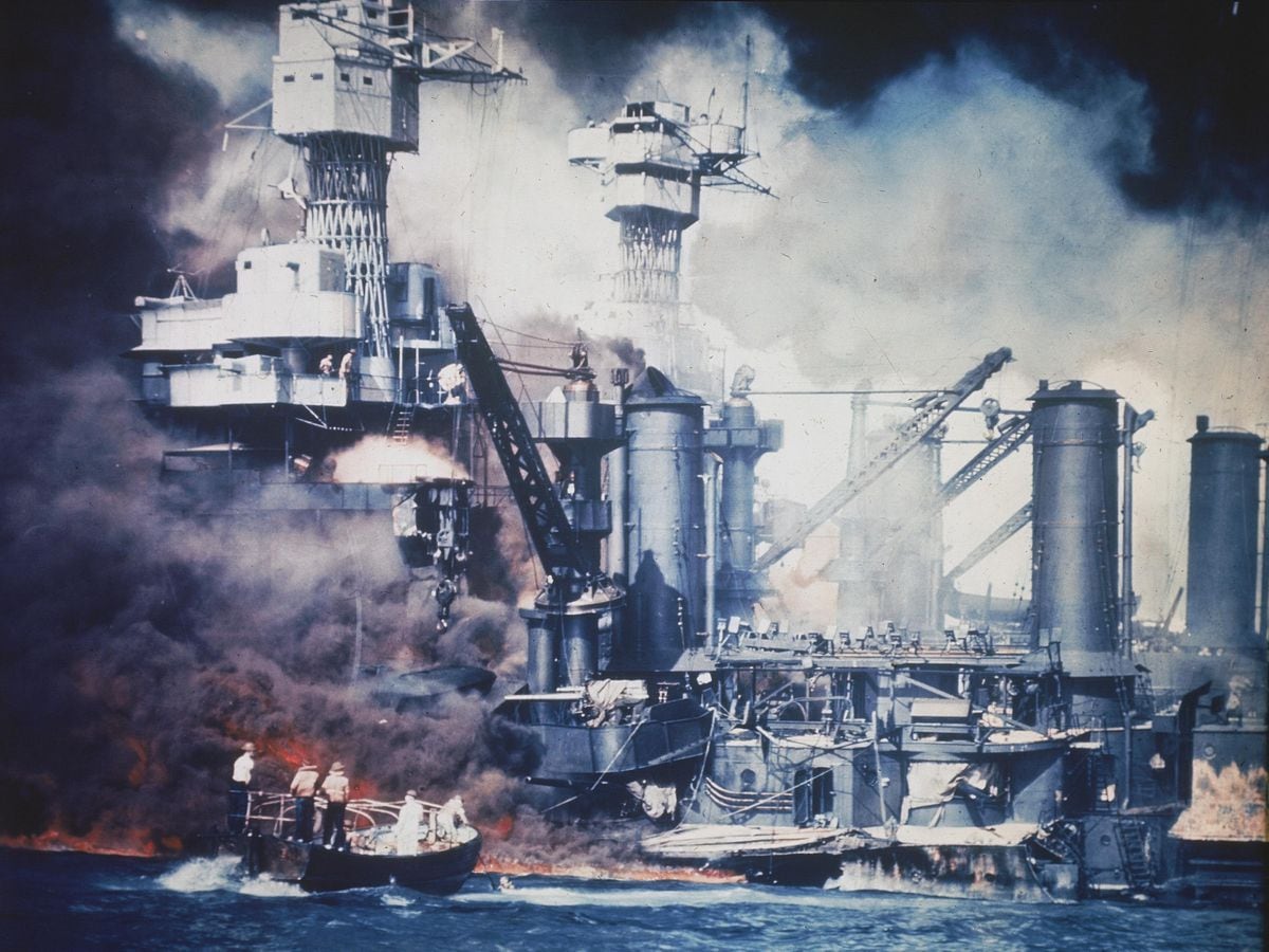 A small boat rescues a USS West Virginia crew member from the water.