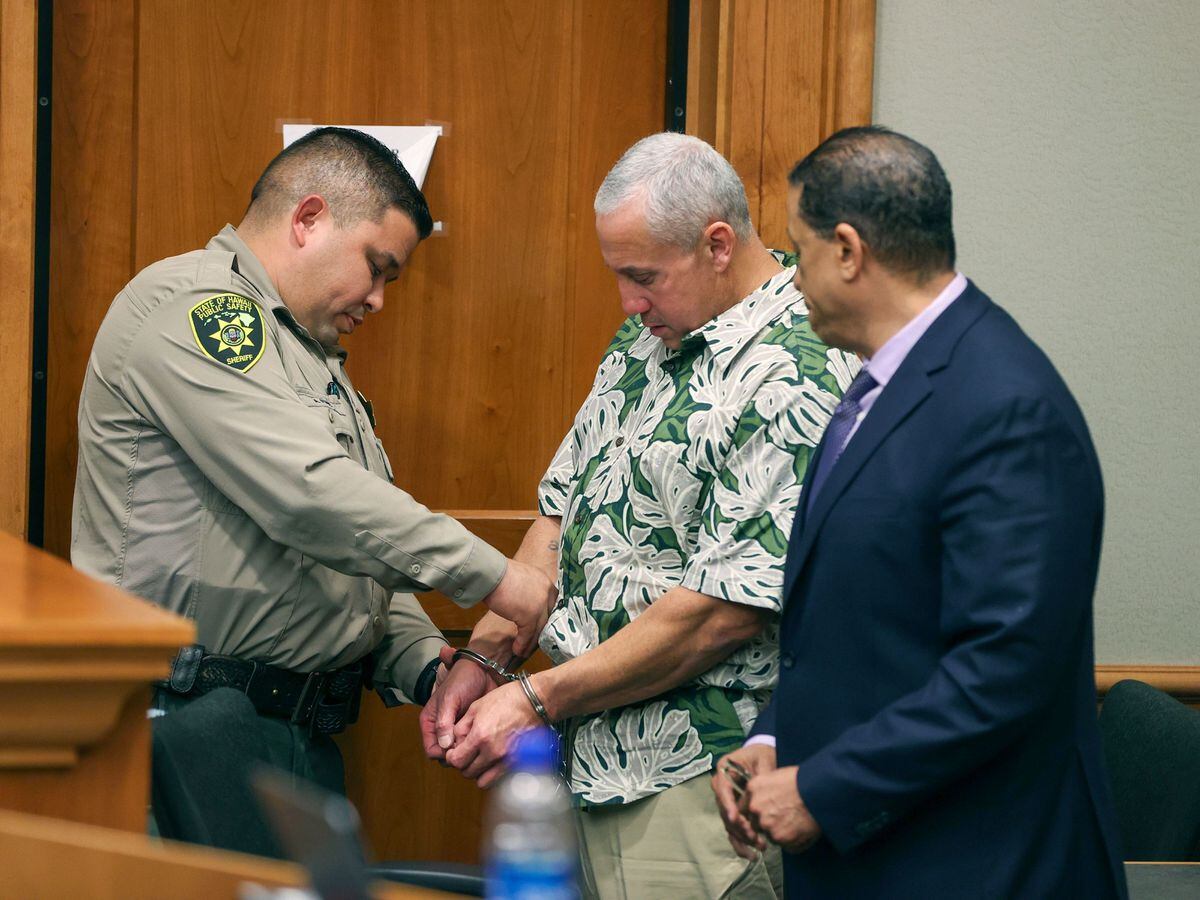 A court officer removes Albert 'Ian' Schweitzer’s handcuffs following the judge’s decision to release him from prison immediately
