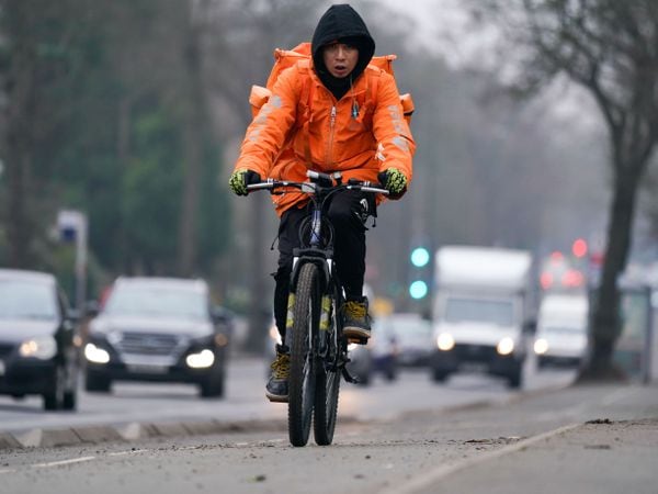A woman rides along a cycle lane next to heavy traffic in Birmingham