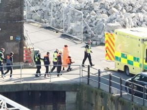 Migrants are led to an ambulance at the Port of Dover