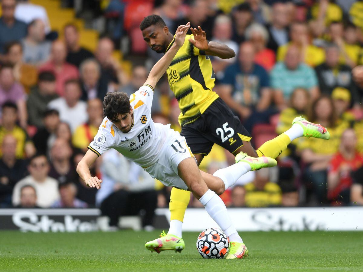 WATFORD, ENGLAND - SEPTEMBER 11: Francisco Trincao of Wolverhampton Wanderers is challenged by Emmanuel Dennis of Watford FC during the Premier League match between Watford and Wolverhampton Wanderers at Vicarage Road on September 11, 2021 in Watford, England. (Photo by Harriet Lander - WWFC/Wolves via Getty Images).