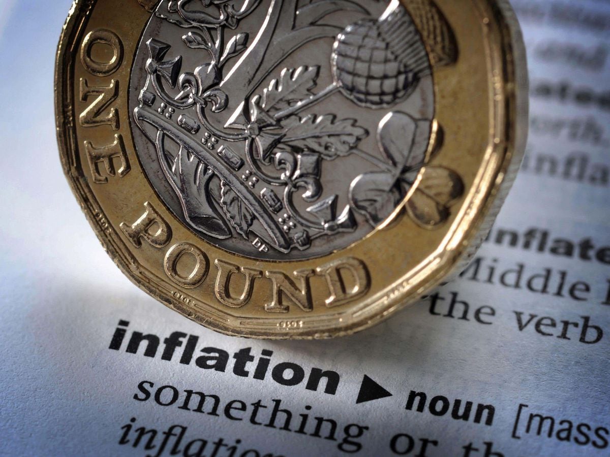 A pound coin on top of 'Inflation' in a dictionary