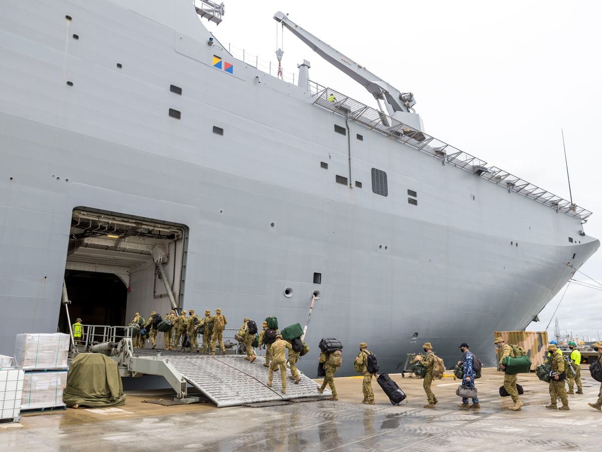In this photo provided by the Australian Defence Force, soldiers load onto HMAS Adelaide at the Port of Brisbane