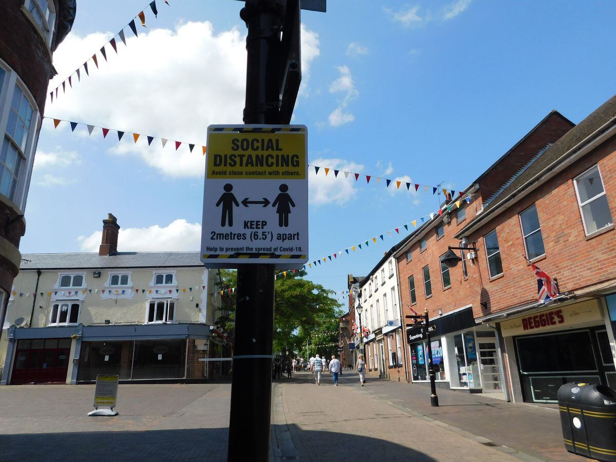 A sign reminding visitors to practice social distancing In Stone High Street