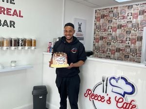 Reece Lambert, owner of Reece's Cafe with a celebratory cake after his grand opening