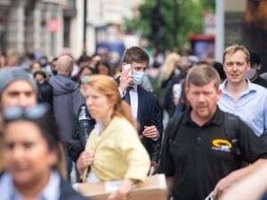 A man wearing a face mask among a crowd of pedestrians on Oxford Street, London.