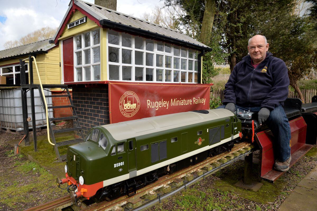 John Dutton shows off a miniature train at the track 