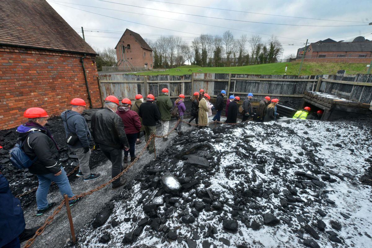 The group of members and staff file down into the mine for the tour