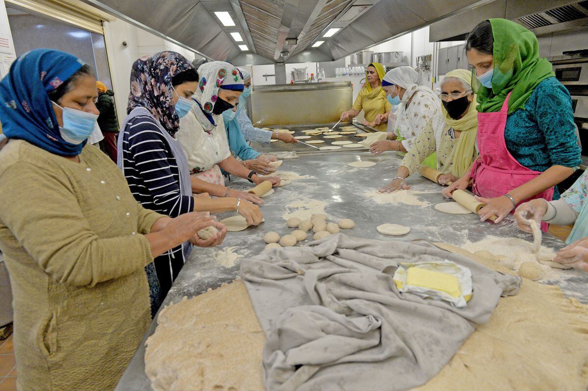 Volunteers work to prepare rotis. Many volunteers give up hours of their time as part of Seva (selfless service)