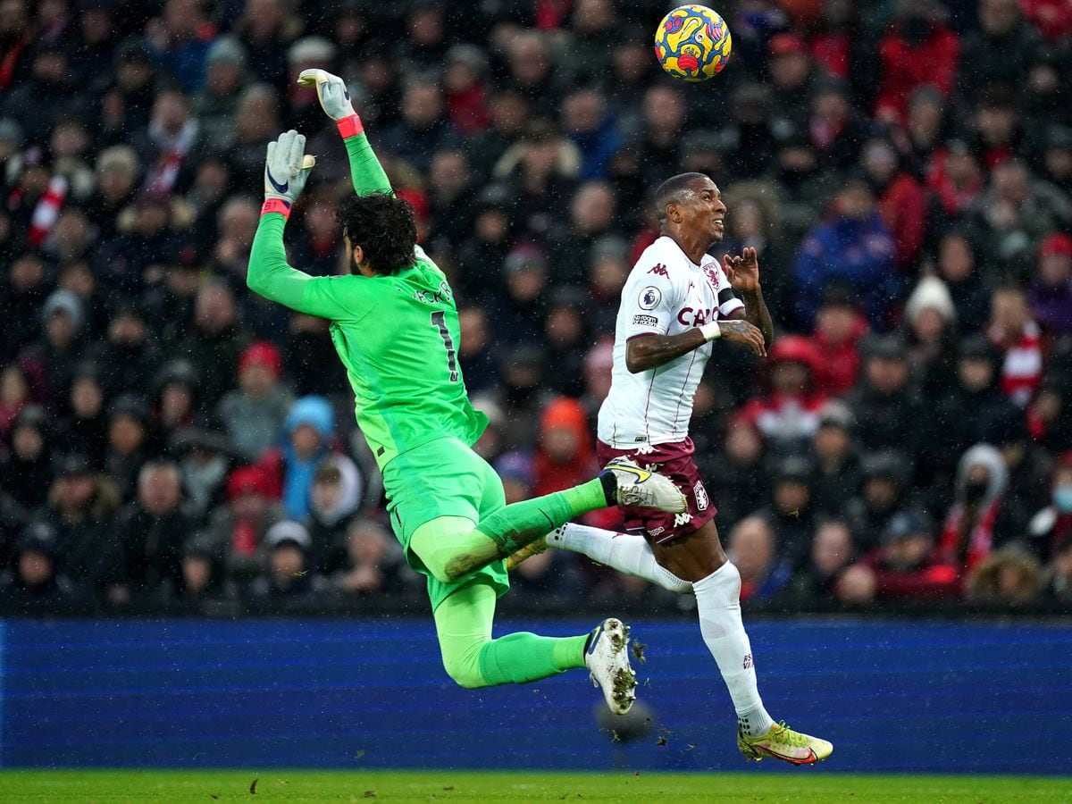 Liverpool goalkeeper Alisson (left) and Aston Villa's Ashley Young battle for the ball             