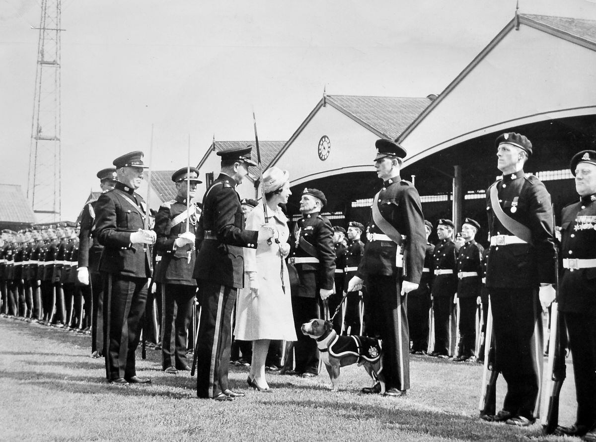 Escorted by three regimental colonels holding drawn swords, the Queen inspects members of the 5/6th Battalion, The North Staffordshire Regiment, at the Molineux ground, Wolverhampton