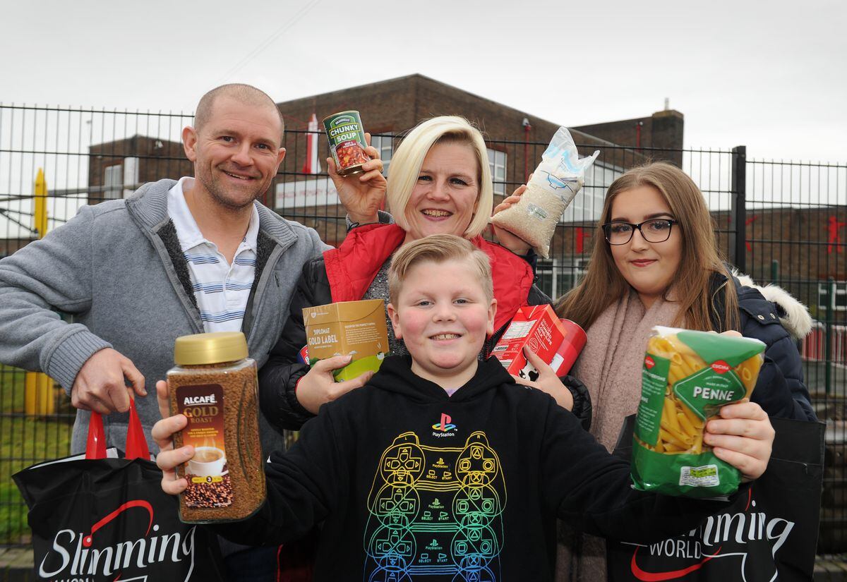 Shane Ruby, Kim Ruby, Lauren Ruby and (front) Craig Ruby pose outside Craig's school, Beacon Primary school in Willenhall with some of the bags of food donated