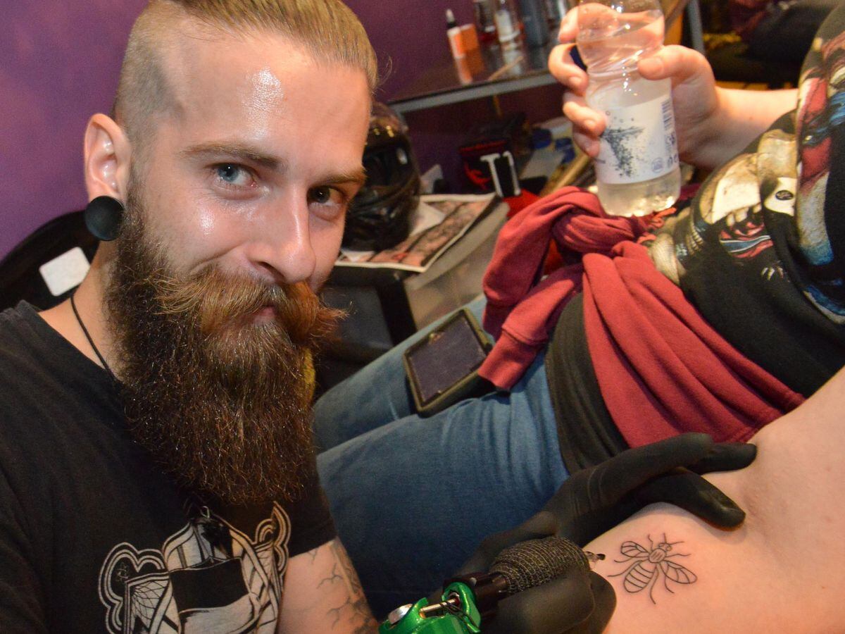 Tattoo artist Mantas Zorys working on a Bee tattoo for Rebecca Beach