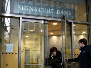 A woman leaves a branch of Signature Bank in New York, Monday, March 13, 2023