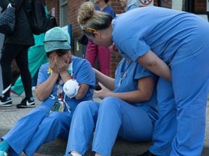 A nurse is comforted by colleagues after she is emotionally overcome during the 8pm clap for carers in Kingston-upon-Thames, UK